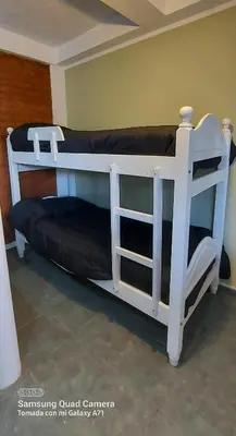 a white bunk bed in a room with a couch at Merlo 1 in Merlo