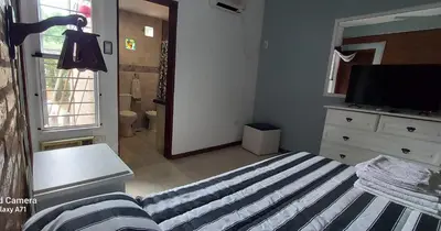 a bedroom with a bed and a dresser and a television at Merlo 1 in Merlo