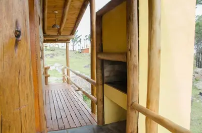 a wooden staircase leading to a building with a porch at Cabañas Agalma in Villa Yacanto