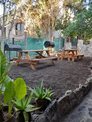 two picnic tables and a grill in a park at Complejo de Cabañas Estancia Del Águila in Mina Clavero