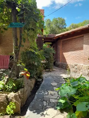 a garden with a stone path next to a brick building at Complejo de Cabañas Estancia Del Águila in Mina Clavero