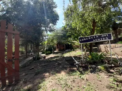 a sign in a yard next to a fence at Complejo de Cabañas Estancia Del Águila in Mina Clavero