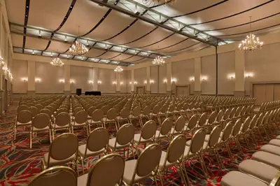 an empty hall with chairs and a grand piano at Quinto Centenario Hotel in Cordoba