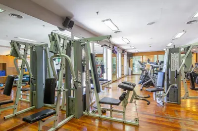 a gym with rows of treadmills and ellipticals at Quinto Centenario Hotel in Cordoba