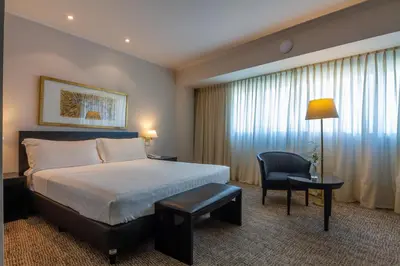 a hotel room with a bed and a chair at Quinto Centenario Hotel in Cordoba