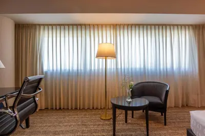 a hotel room with a table and chairs and a lamp at Quinto Centenario Hotel in Cordoba