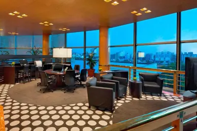 a large room with chairs and tables and windows at Quinto Centenario Hotel in Cordoba