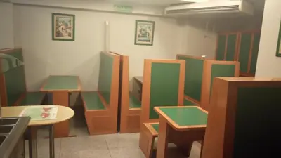 a room with green and brown chairs and tables at Apart Hotel Magali in Cordoba