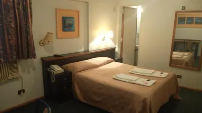 a hotel room with a bed with two towels on it at Apart Hotel Magali in Cordoba
