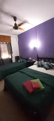 a bedroom with two beds and a purple wall at Residencial Ariand in Santa Rosa de Calamuchita