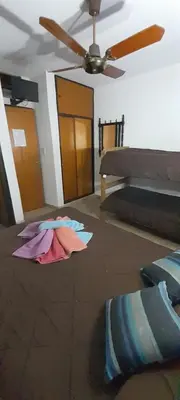 a room with two beds and a ceiling fan at Residencial Ariand in Santa Rosa de Calamuchita