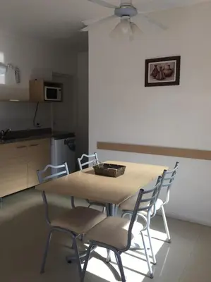 a dining room table with chairs and a ceiling fan at Altos Serranos Apart in Merlo