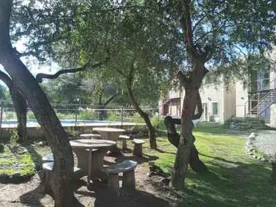 a picnic table and benches under a tree at Altos Serranos Apart in Merlo