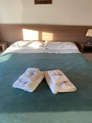 a bed with two towels sitting on top of it at Altos Serranos Apart in Merlo