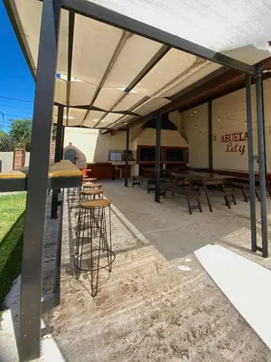 a patio with tables and chairs under a pavilion at Complejo Abuela Lety in Merlo