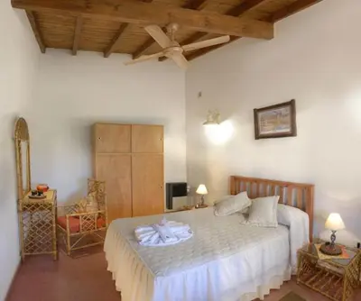 a bedroom with a large bed in a room at Posada Jardin del Cerro in Santa Rosa de Calamuchita