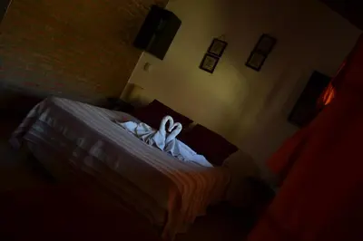 a bedroom with a bed with two swans on it at Cabañas de los Comechingones in Merlo