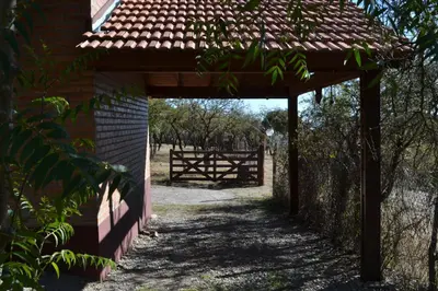 a wooden pergola with a gate and a fence at Cabañas de los Comechingones in Merlo