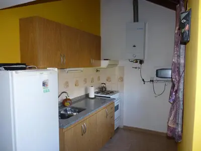 a small kitchen with a sink and a refrigerator at Cabañas de los Comechingones in Merlo