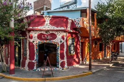 a red building with a painting on the side of it at La Neofita in Mina Clavero