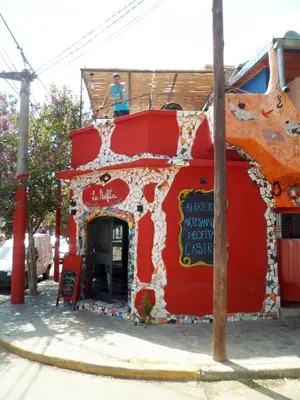 a person sitting on top of a red building at La Neofita in Mina Clavero