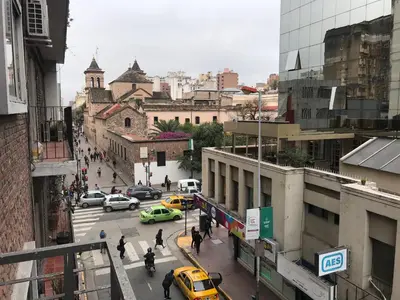 a busy city street with cars and people and buildings at Cordoba Inn Apart Hotel in Cordoba