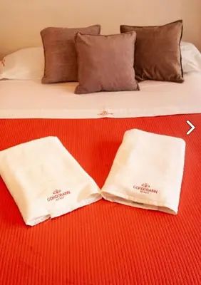 two white towels are sitting on a bed at Cordoba Inn Apart Hotel in Cordoba