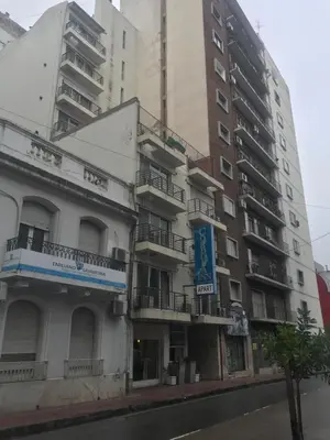 a tall building with a sign in front of it at Cordoba Inn Apart Hotel in Cordoba