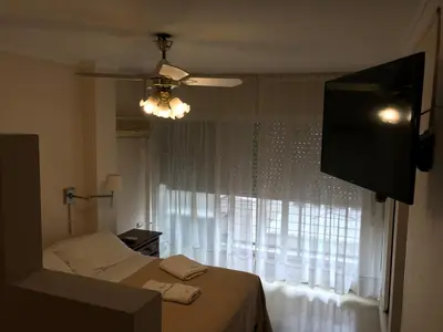 a bedroom with a bed and a flat screen tv at Cordoba Inn Apart Hotel in Cordoba