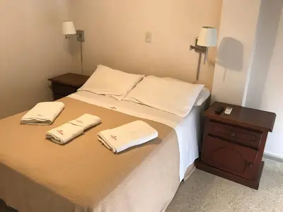 a bedroom with a bed with two towels on it at Cordoba Inn Apart Hotel in Cordoba