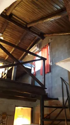 an attic room with a wooden ceiling and a window at Cabaña Silvana in Bialet Massé