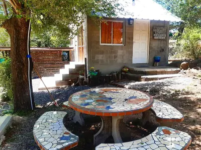a table with a mosaic top in front of a house at Cabaña Silvana in Bialet Massé