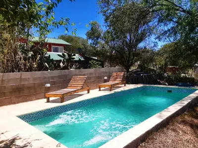 a swimming pool with two chairs and a swimming pool at Cabaña Silvana in Bialet Massé