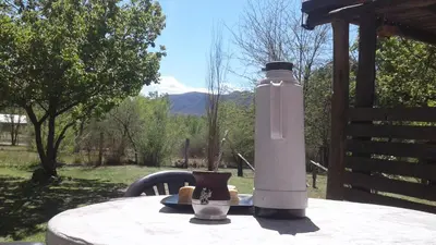 a table with a bottle sitting on top of it at Cabaña Silvana in Bialet Massé