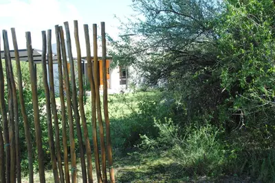 a fence with wooden poles in a yard at Casas del Champaquí in San Javier