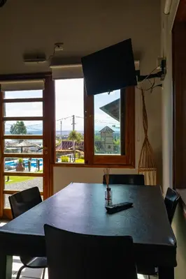 a dining room table with chairs in front of a window at Portal de la Virgen in Villa General Belgrano