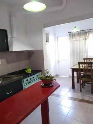 a kitchen with a stove and a table in a room at LF Departamentos in Cordoba