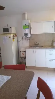 a kitchen with a refrigerator and a table with chairs at LF Departamentos in Cordoba