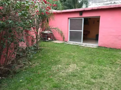 a pink house with a window and a yard at LF Departamentos in Cordoba