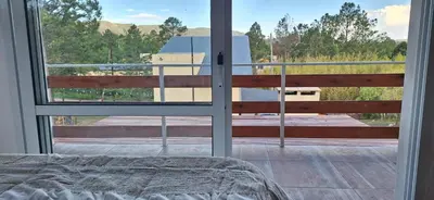 a bedroom with a window looking out at a building at Terrazas de Nahuascat in Santa Rosa de Calamuchita