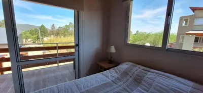 a bedroom with a bed and a large window at Terrazas de Nahuascat in Santa Rosa de Calamuchita