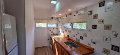 a small kitchen with a sink and a refrigerator at Terrazas de Nahuascat in Santa Rosa de Calamuchita