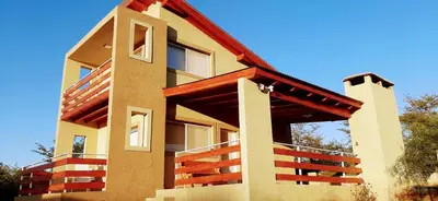 a building with wooden balconies on the side of it at Terrazas de Nahuascat in Santa Rosa de Calamuchita