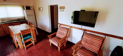 a living room with two chairs and a television on a wall at Terrazas de Nahuascat in Santa Rosa de Calamuchita