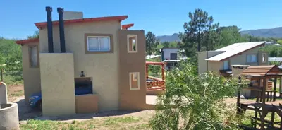 a small house with a fireplace in a yard at Terrazas de Nahuascat in Santa Rosa de Calamuchita