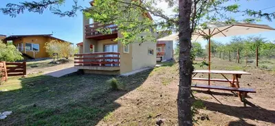 a building with a picnic table next to a tree at Terrazas de Nahuascat in Santa Rosa de Calamuchita