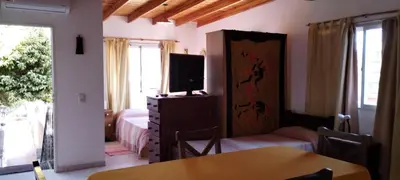a bedroom with a bed and a television and a table at Departamento Con Vistas a La Montaña in Villa Carlos Paz
