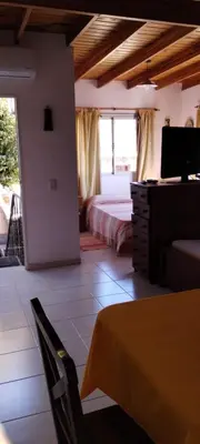 a bedroom with a bed and a desk and a television at Departamento Con Vistas a La Montaña in Villa Carlos Paz