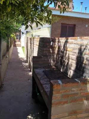 a wooden bench sitting next to a brick wall at Departamento Con Vistas a La Montaña in Villa Carlos Paz
