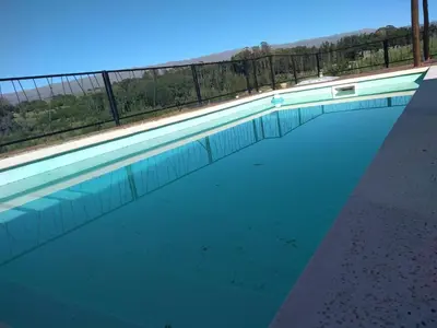 an empty swimming pool with a fence and water at Gran Cabaña en Villa Yacanto in Villa Yacanto